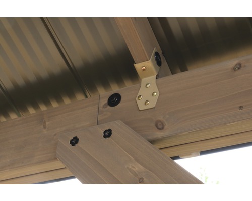 Detail dřevěné konstrukce zahradního domku s kovovým úhelníkem a šrouby