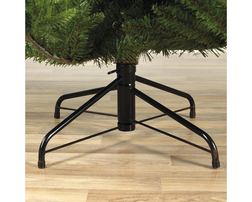 Detailní záběr černé kovové základny umělého vánočního stromku.