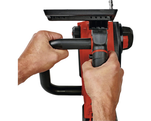 Osoba drží v obou rukách řetězovou pilu.