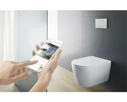 Osoba ovládá sprchové WC pomocí aplikace na smartphonu