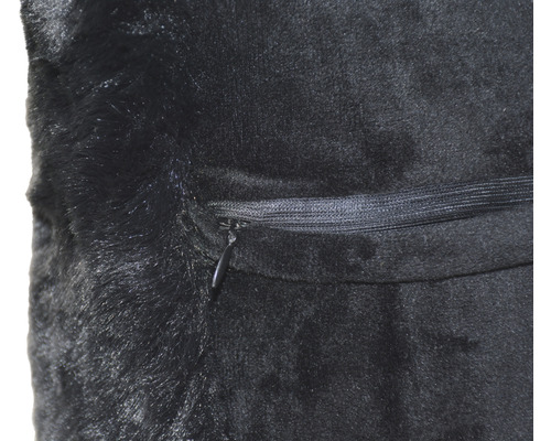 Detailní záběr černého polštáře z umělé kožešiny se zipem