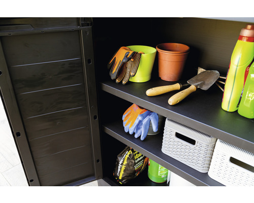 Otevřená zahradní skříň s policemi, plná zahradního nářadí, květináčů a zahradních doplňků