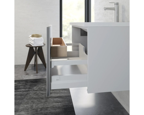 Koupelna s umyvadlovou skříňkou, umyvadlem a otevřenou zásuvkou na koupelnové potřeby