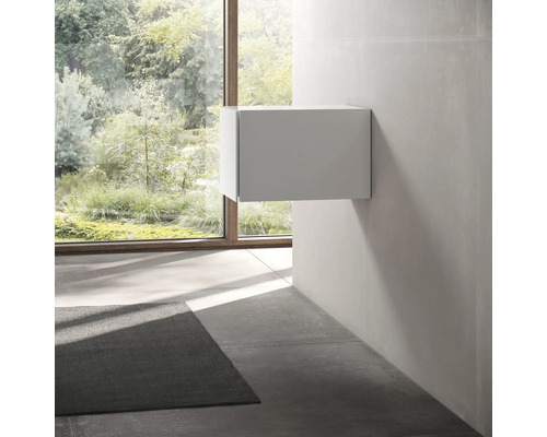 Moderní koupelna s bílou závěsnou skříňkou pod umyvadlo a velkým oknem