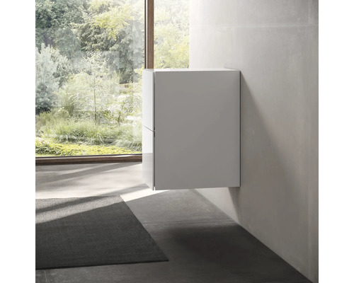 Závěsná koupelnová skříňka v světlé místnosti s oknem a kobercem