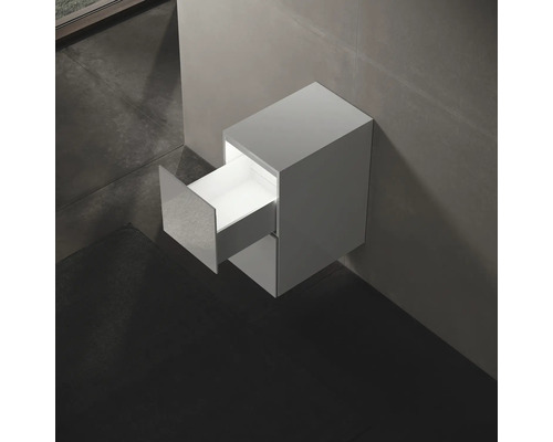 Závěsná skříňka pod umyvadlo s otevřenou zásuvkou v koupelně.