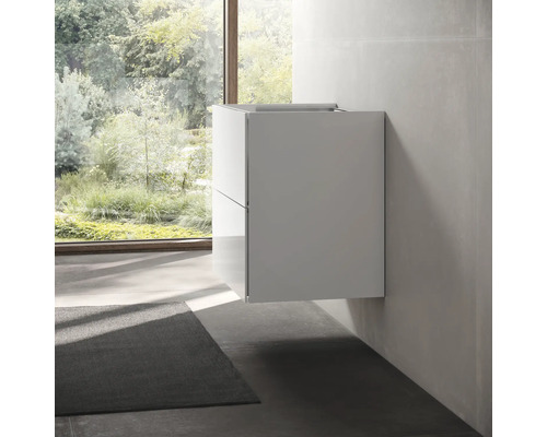 Moderní koupelna s bílou skříňkou pod umyvadlo a oknem