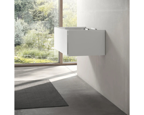 Moderní koupelna se závěsnou skříňkou pod umyvadlo a oknem