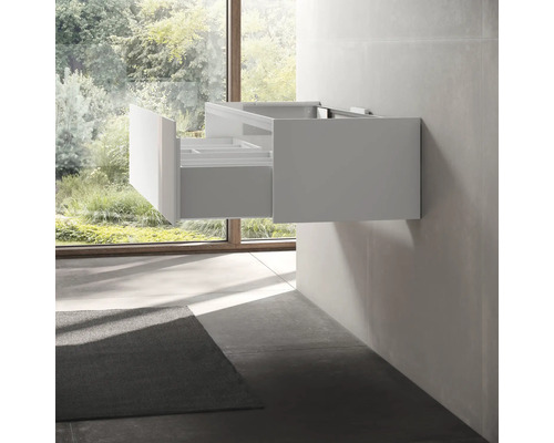 Moderní koupelna s umyvadlovou skříňkou a otevřenou zásuvkou.