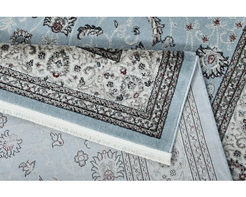 Detail světlého koberce s květinovým vzorem