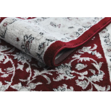 Detail vzorovaného koberce s květinovým designem a bordurou