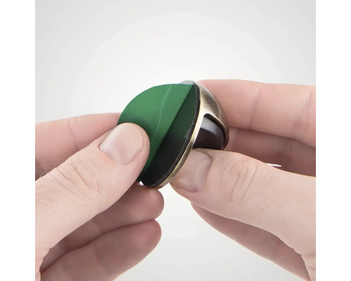 Osoba odstraňuje ochrannou fólii z dveřního dorazu s lepicí plochou