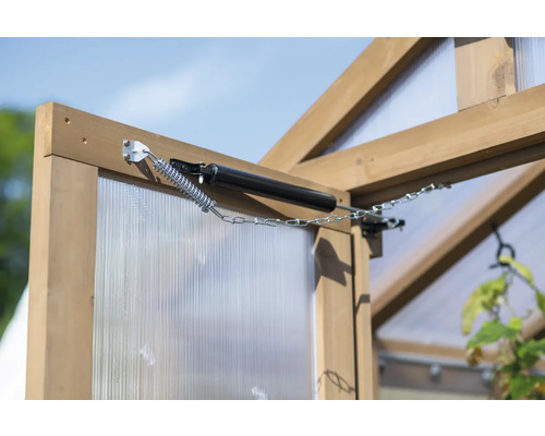 Detailní záběr automatického otvírače oken na okně skleníku