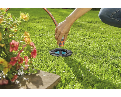 Zavlažování zahrady se zatahovacím čtyřplošným zavlažovačem v trávníku.