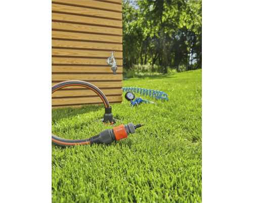 Zahradní scéna s kohoutkem, zahradní hadicí a konektorem na trávníku