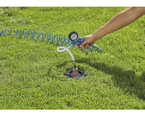 Postřikovač instalovaný v trávníku je kontrolován pomocí tlakového testeru.