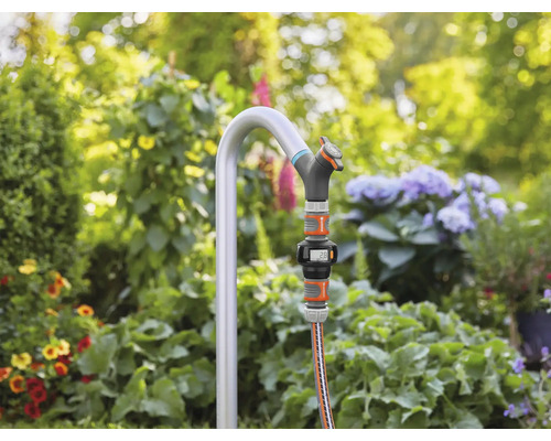 Zahradní scéna s kohoutkem, hadicí a digitálním vodoměrem na zahradě