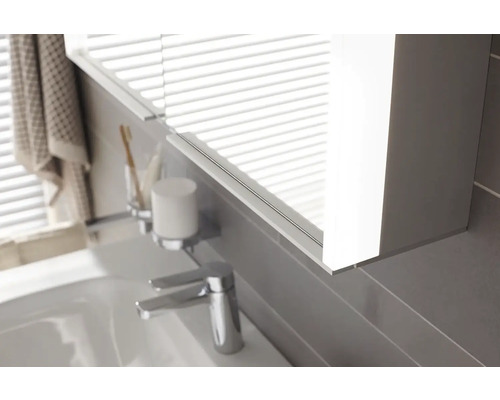 Detail koupelny s osvětlenou zrcadlovou skříňkou, umyvadlem a vodovodní baterií