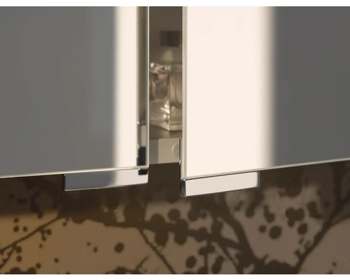 Detail bílých skříňkových dveří s kovovými úchyty