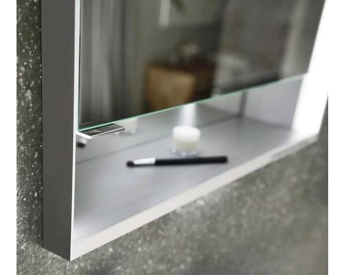 Detail skříňky se zrcadlem s kosmetickým štětcem a krémem