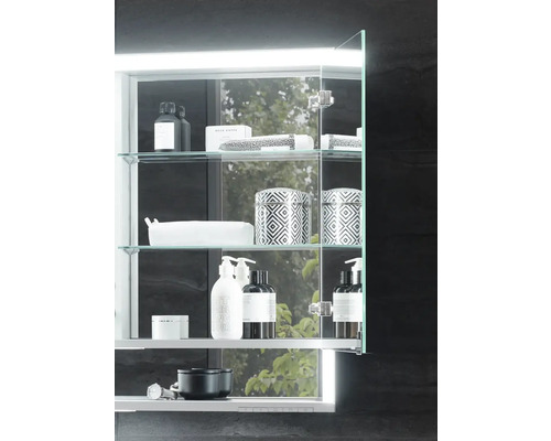 Koupelnová zrcadlová skříňka se skleněnými policemi a různými koupelnovými doplňky