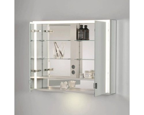 Otevřená zrcadlová skříňka se skleněnými policemi, vnitřním osvětlením a koupelnovými doplňky
