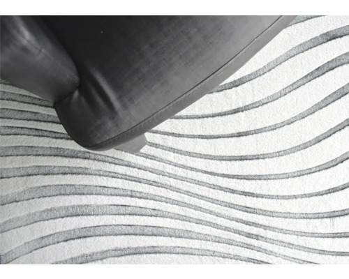 Koberec s vlnitým vzorem pod kusem nábytku