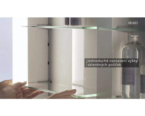 Vnitřní pohled do zrcadlové skříňky se skleněnými policemi a variabilním nastavením výšky