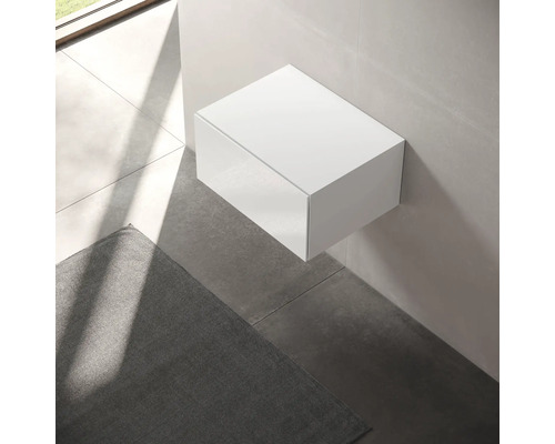 Bílá závěsná skříňka v koupelně.