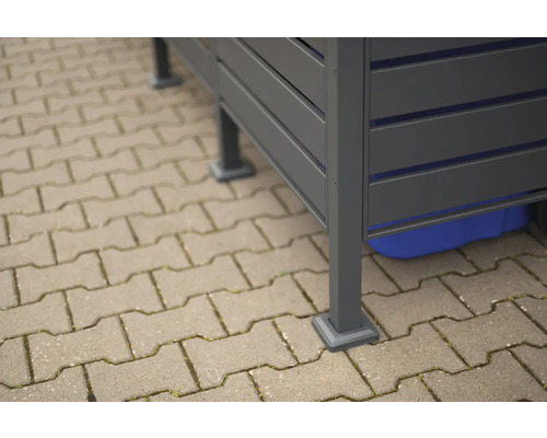 Detailní pohled na šedý zahradní domek na dlažebních kostkách.