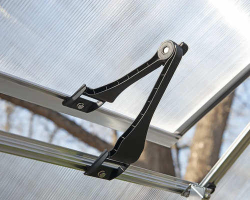 Detailní pohled na otvírač oken na okně skleníku.