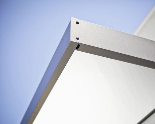 Detail rohového spoje kovového rámu se šrouby na světlém pozadí