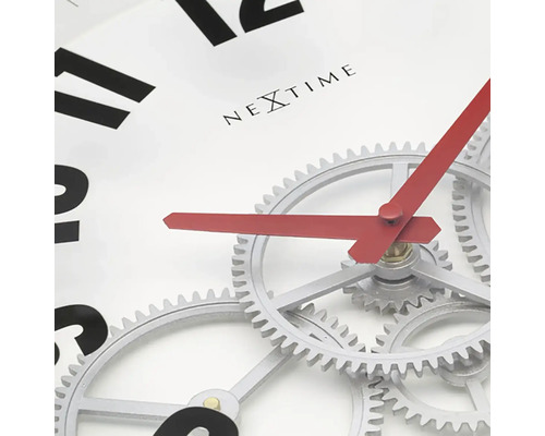 Detailní pohled na nástěnné hodiny Nextime s viditelným hodinovým strojkem a červenými ručičkami