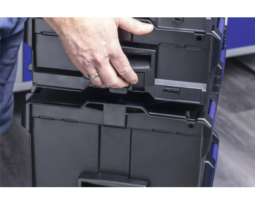 Osoba otevírá plastový box na nářadí.