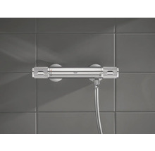 Sprchová baterie Grohe s hadicí na šedé zdi