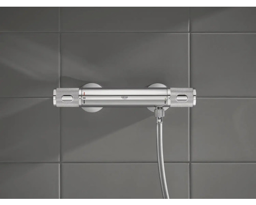 Sprchová baterie Grohe s hadicí na šedé zdi