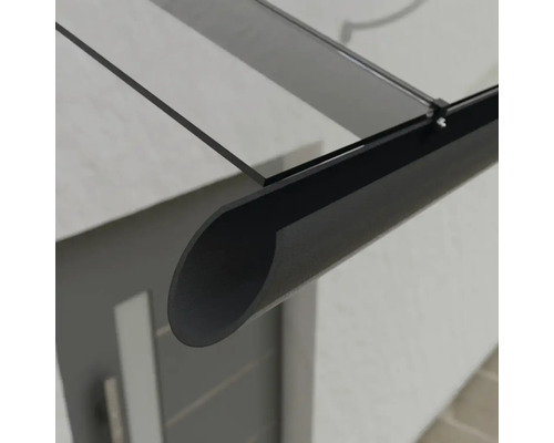 Detailní záběr skleněné a kovové stříšky nad vchodovými dveřmi.