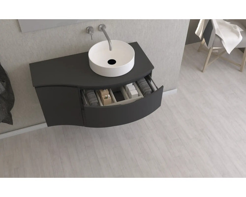 Umyvadlová skříňka s otevřenou zásuvkou a umyvadlem na desku v koupelně.