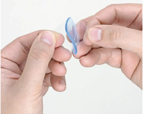 Dvě ruce drží průhledné samolepicí podložky