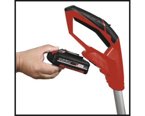 Ruka drží baterii Einhell Power X-Change u červené rukojeti zahradního nářadí