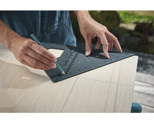 Osoba kreslí čáru tužkou a multifunkčním úhelníkem na dřevěné desce