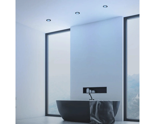 Moderní koupelna s volně stojící vanou, stropními světly a velkým oknem