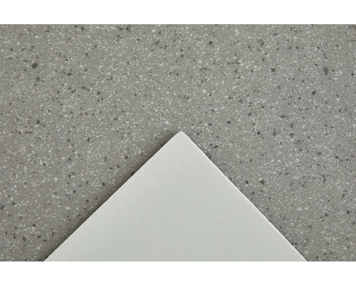 Detail bílé dlaždice na skvrnitém povrchu