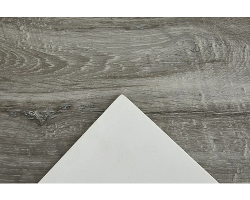 Bílá keramická dlaždice na dřevěném pozadí