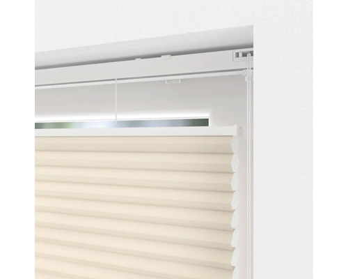 Detail béžové plisované žaluzie v okně