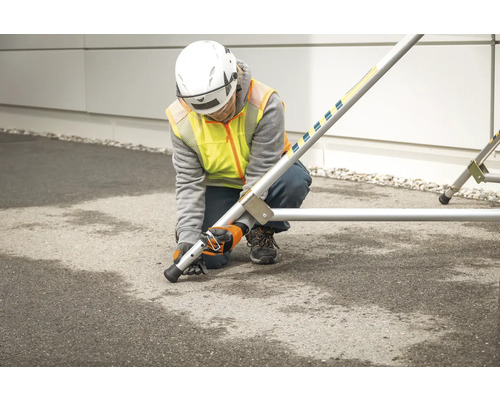Osoba montuje lešení s vyrovnávacími patkami.