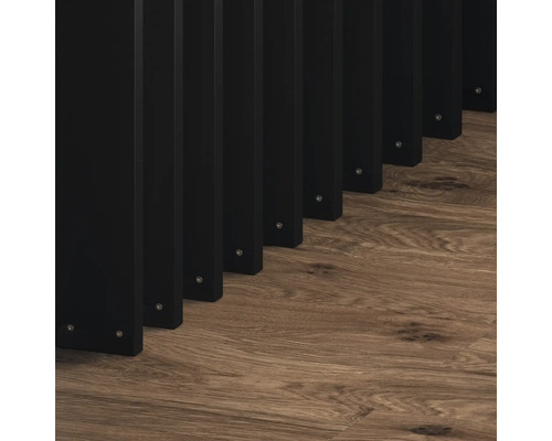 Černý dřevěný lamelový plot na dřevěné podlaze