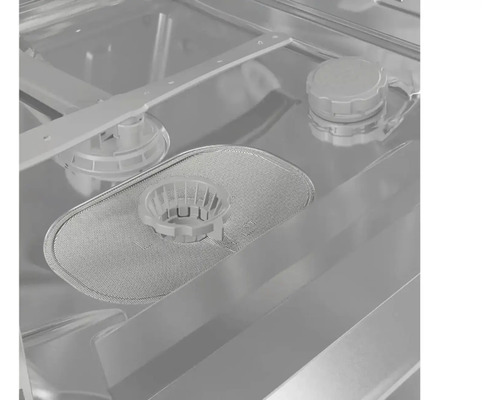 Vnitřek myčky s filtrem, ostřikovacím ramenem a přihrádkou na čisticí prostředek