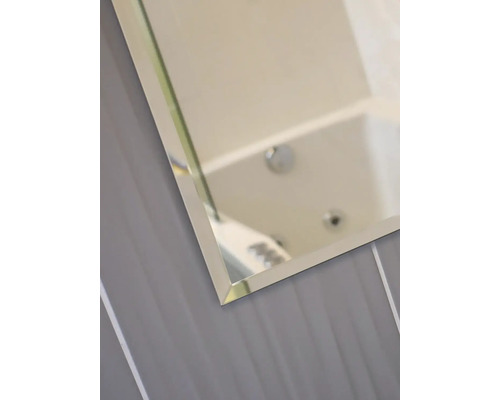 Detail zrcadla se skleněným rámem v koupelně