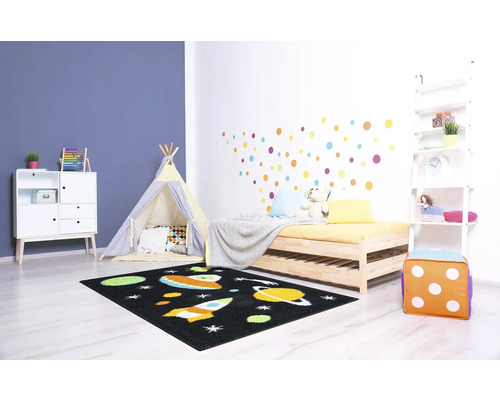 Dětský pokoj s postelí, kobercem s motivem vesmíru, hracím stanem a bílou skříní